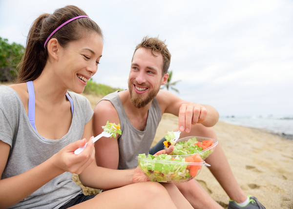 couple-eating-salad-healthy-beach-date-ocean